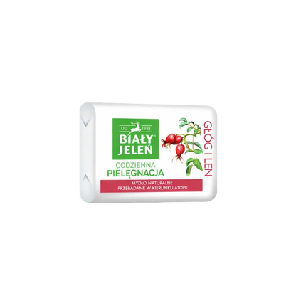 Bar of soap with a white packaging featuring green and red elements on a light gray background