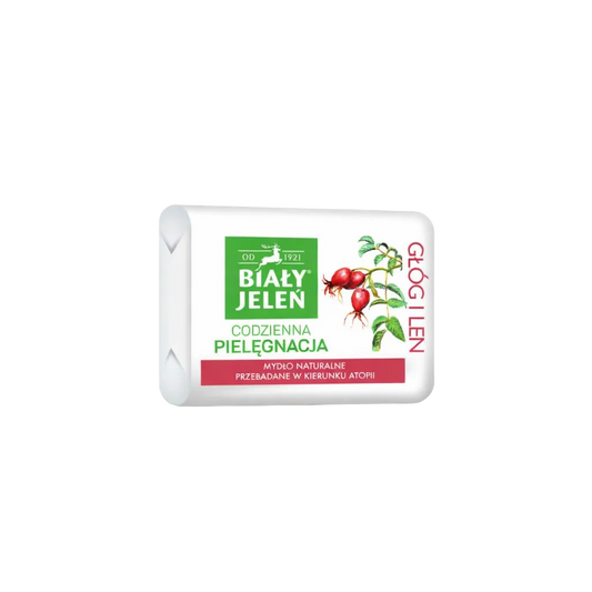 Bar of soap with a white packaging featuring green and red elements on a light gray background