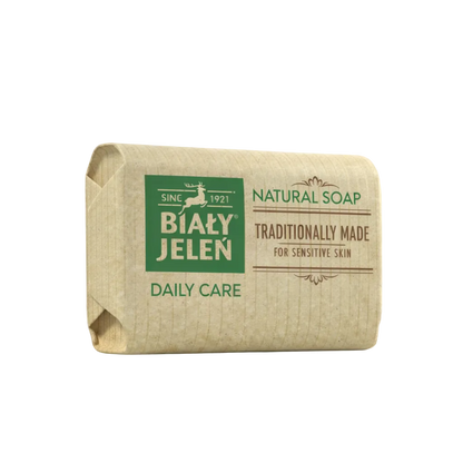Bar of natural soap with Bialy Jelen branding on a light background