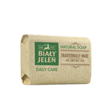 Bar of natural soap with Bialy Jelen branding on a light background