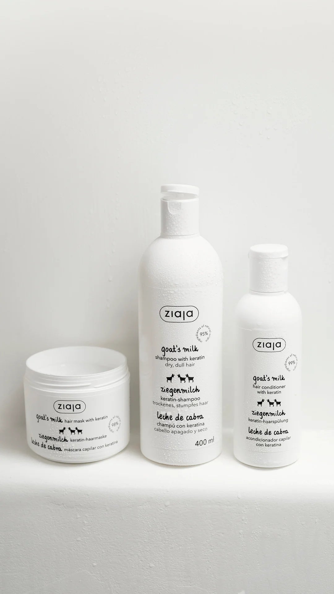 Three white pet grooming products from the brand ziqo, including a jar, a medium bottle, and a smaller bottle, arranged on a light gray surface against a white background.