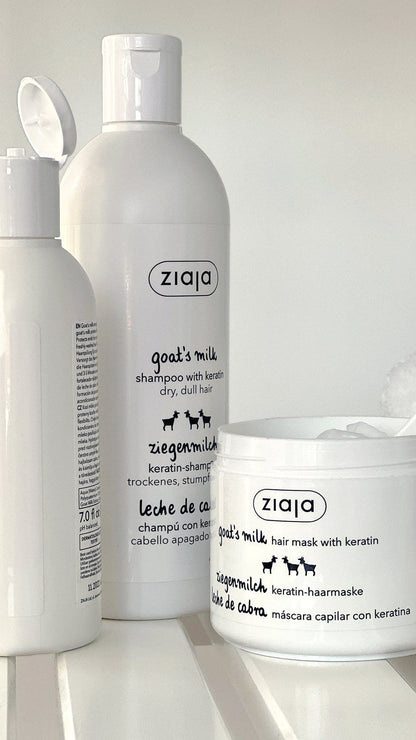 Three white pet grooming products from the brand ziaja, including shampoo, conditioner, and a hair mask, arranged on a white surface against a light background.